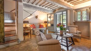 A rustic interior with exposed wooden beams, a stone floor, and a cozy seating area with a sofa and armchairs. - Wonderful  villa for 5 people with pool, WIFI, TV and patio (Vivo D'orcia)