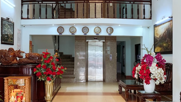 A spacious lobby with a high ceiling, a staircase, and a reception desk. - Rang Dong hotel (Hue)