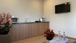 A modern kitchen with a microwave, sink, and a flat-screen TV mounted on the wall. - Rang Dong hotel (Hue)