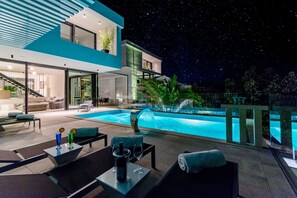 A modern house with a swimming pool, outdoor seating, and a staircase leading to the interior. - Luxury Villa Luna with Swimming Pool (Sutivan)