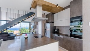 A modern kitchen with a built-in Bosch refrigerator, a coffee machine, and a sleek island. - Luxury Villa Soleil with Swimming Pool (Sutivan)