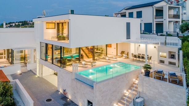 A modern multi-story house with a rooftop pool, glass walls, and a staircase leading to the upper levels. - Luxury Villa Soleil with Swimming Pool (Sutivan)