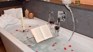 A bathtub with rose petals, candles, and wine glasses. - Comfort Chalet Mühle - SKI in/SKI out, Sauna-Jacuzzi - by "wachterhof" (Kaltenbach)