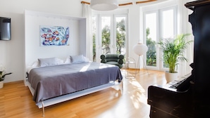 A modern bedroom with a bed, a piano, and a chair. - Luxury Residence Queen of Dubrovnik (Dubrovnik)