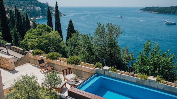 A swimming pool with a view of the sea and a mountainous landscape. - Luxury Residence Queen of Dubrovnik (Dubrovnik)