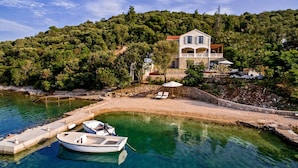 A coastal villa with a stone facade, a balcony, and a clear view of the sea. - Beachfront Villa Feodora Grande (Korcula)