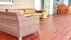 En fletsofa med puder på en træterrasse.