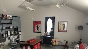 A cozy living room with a dining area, featuring a red table and chairs, a vintage suitcase, and a bicycle. - Urban Chic Studio, Private, 1B1B.  Belhaven area.   Near campus& hospitals. (Jackson)