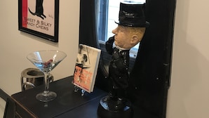 A bar area with a vintage poster, a martini glass, a book, and a figurine. - Urban Chic Studio, Private, 1B1B.  Belhaven area.   Near campus& hospitals. (Jackson)