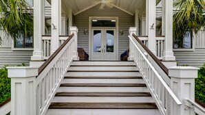 A staircase leading to a porch with white railings and wooden steps.