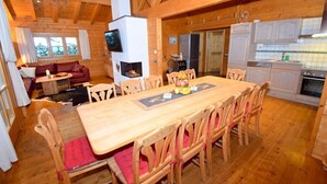 Interior de una cabaña de madera con comedor, cocina y sala de estar.