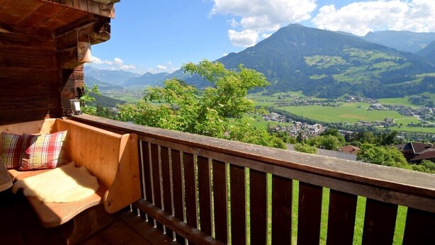 A wooden balcony with a bench and a view of a valley and mountains. - Waldhütte - SKI in/SKI out - by "wachterhof" (Kaltenbach)