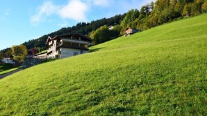 A building with a sloped roof, a visible entrance, and a sign indicating it is a hotel. - Waldhütte - SKI in/SKI out - by "wachterhof" (Kaltenbach)