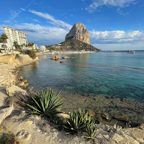 Talo merellä ja vuoristossa pienessä kylässä koristepuiden keskellä