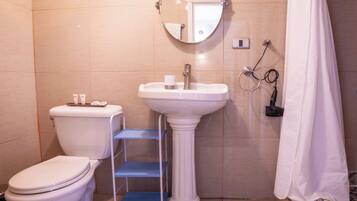 Un baño con inodoro, lavamanos y cortina de ducha.