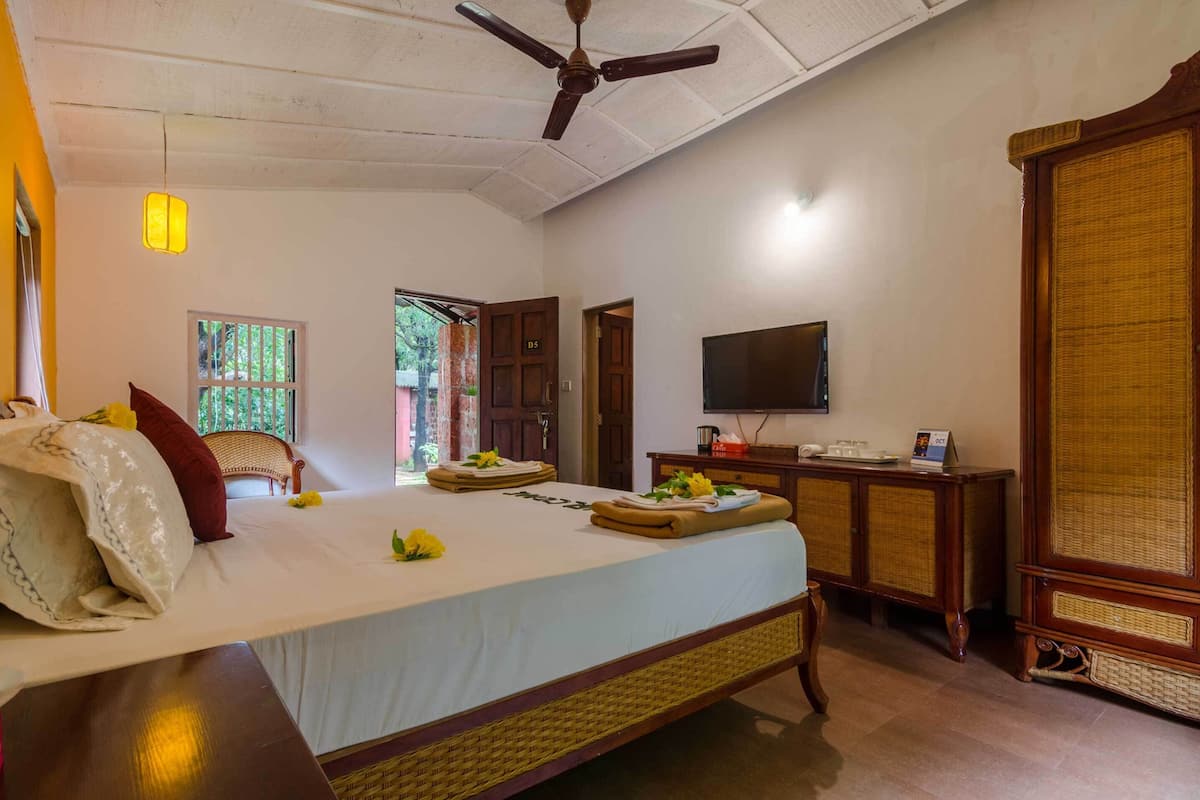 A hotel room with a bed, a television, a desk, and a wardrobe.
