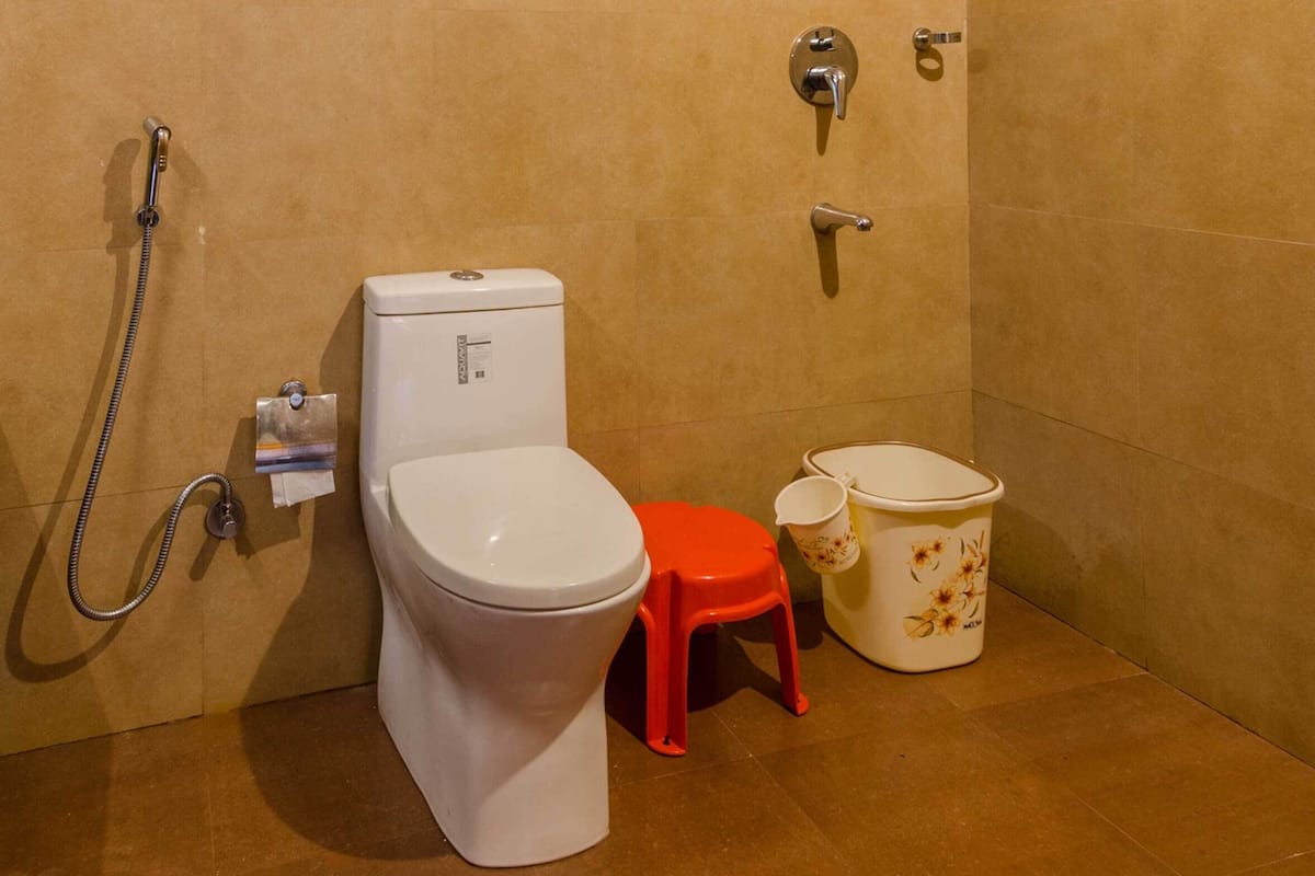 A bathroom with a toilet, bidet, and shower.
