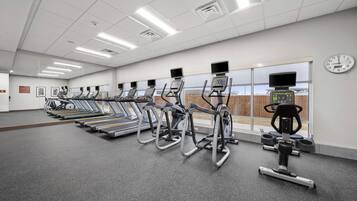 A gym with multiple treadmills, a stationary bike, and a rowing machine.