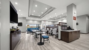 A modern restaurant with a central counter, seating area, and a view of the outdoors. - TownePlace Suites by Marriott Waco Northeast (Waco)