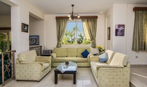 A living room with two sofas, a coffee table, and a chandelier. - Coral Bay Villa. Private Pool (5x10m), Completely Private, VILLAS FOR GROUPS  (Paphos)