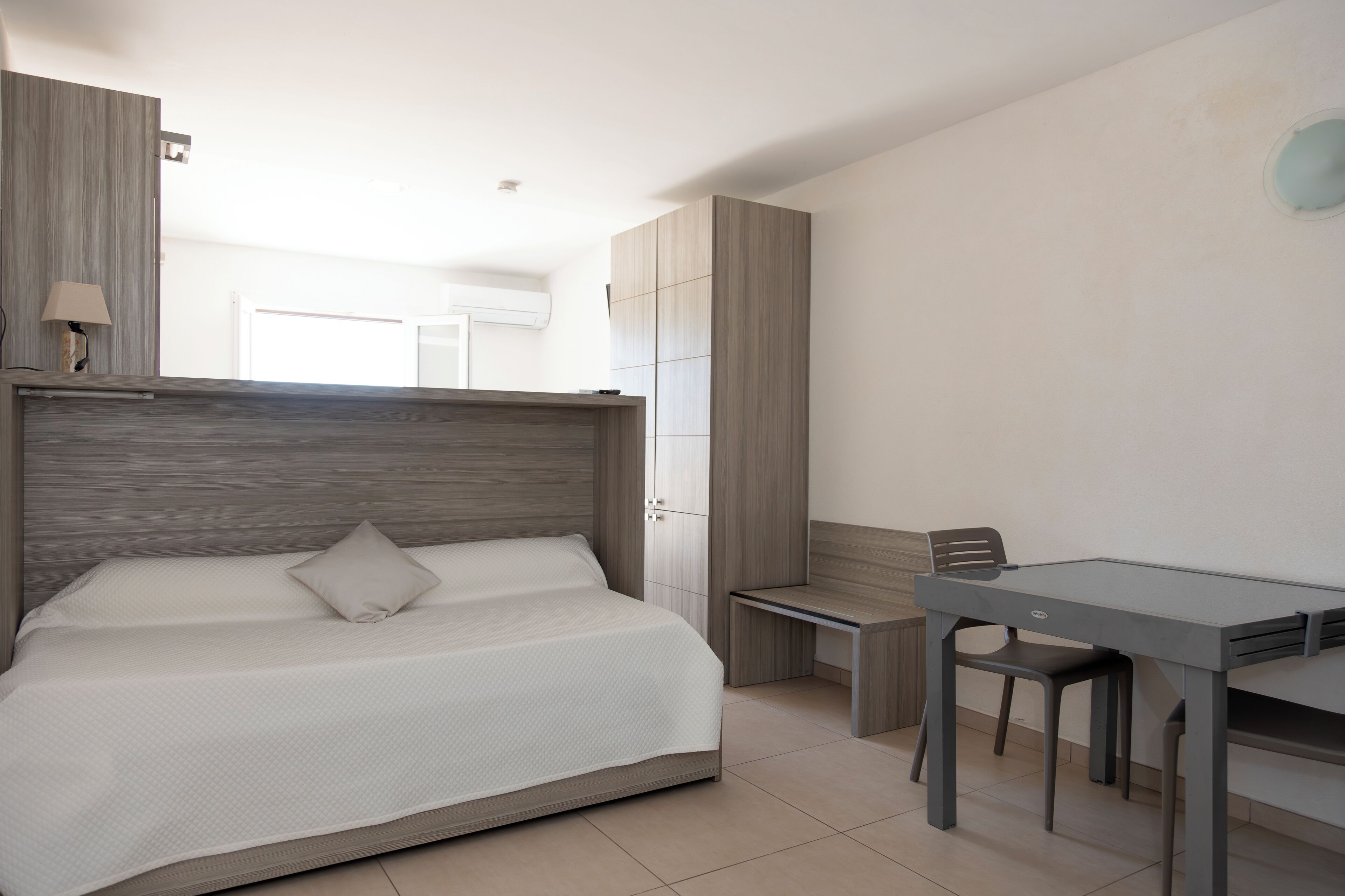 Un dormitorio con cama, escritorio y silla.