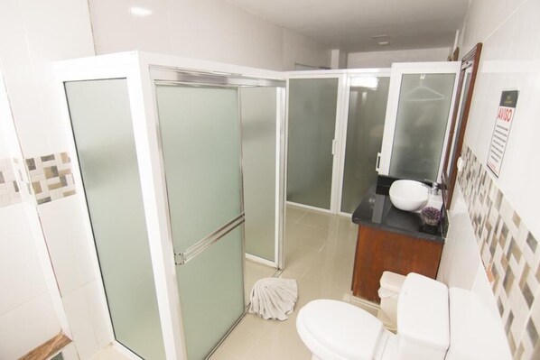 Un baño con ducha, inodoro y lavamanos.