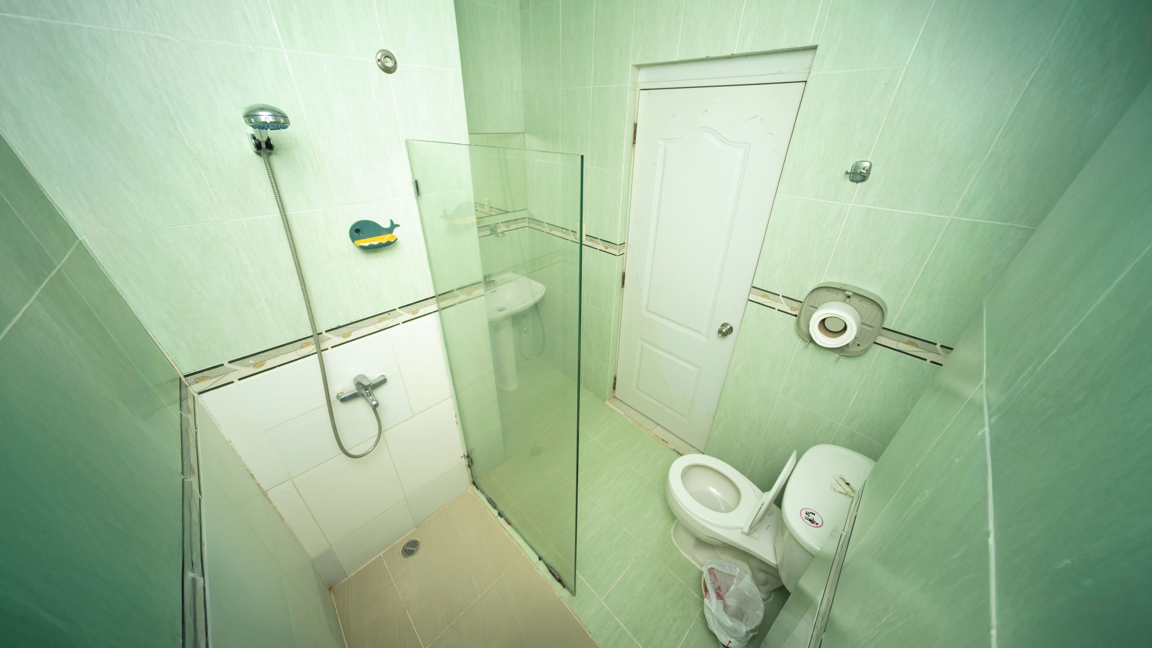 Ein Badezimmer mit Duschkabine, Waschbecken und Toilette.