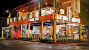 Un restaurant appelé « La Esquina del Sandwich », doté d’une terrasse et d’un escalier bien visible menant à l’entrée.