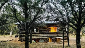 A rustic cabin with a wooden deck and a large window. - Charming Mountain Chalet with Stunning Views (Montrose)