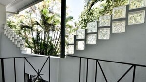 Et moderne interiør med en balkon med udsigt over en have.