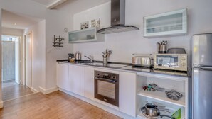 A modern kitchen with a built-in oven, microwave, and stainless steel appliances. - La Dépendance, Magnifique maison climatisée avec jardin (Bordeaux)