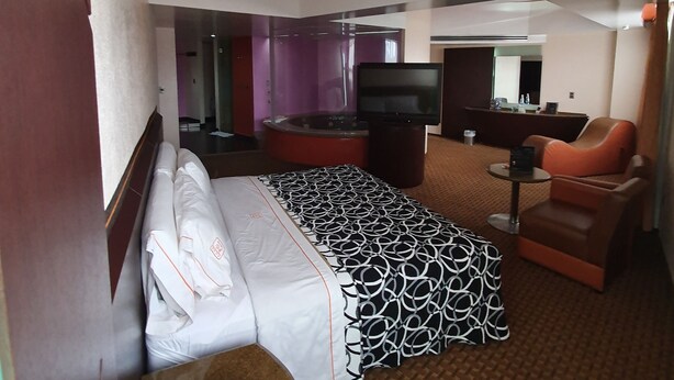 A hotel room with a bed, a desk, a television, and a seating area. - Hotel Valle del Sur (Mexico City)