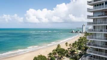 A beachfront hotel with a pool, beach access, and a view of the ocean.
