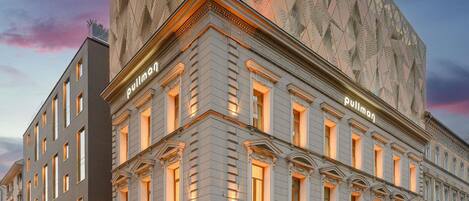 A hotel with a classic facade, multiple windows, and a prominent name sign.