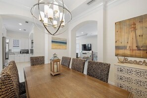 A dining area with a wooden table, woven chairs, and a decorative lantern.