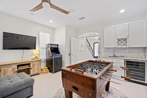 A room with a foosball table, a television, and a gaming console. - Private Beach | Gulf Views | Comm Pool | Elevator (Destin)