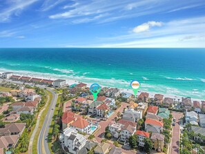 A coastal residential area with houses, a road, and a beach.