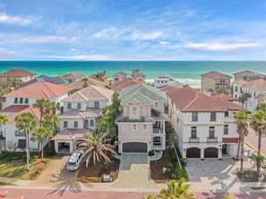 A coastal residential area with houses featuring red-tiled roofs, a central building with a green roof, and a view of the ocean. - Private Beach | Gulf Views | Comm Pool | Elevator (Destin)