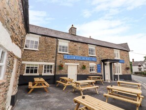 A stone building with a sign reading "Y LLEW GLAS THE BLUE LIONS". - The Blue Lion (Corwen)