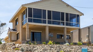 Een huis met twee verdiepingen, een stenen fundering en een balkon.