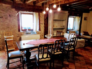 A dining area with a wooden table, chairs, and hanging light bulbs. - Ker Carlines (Targassonne)