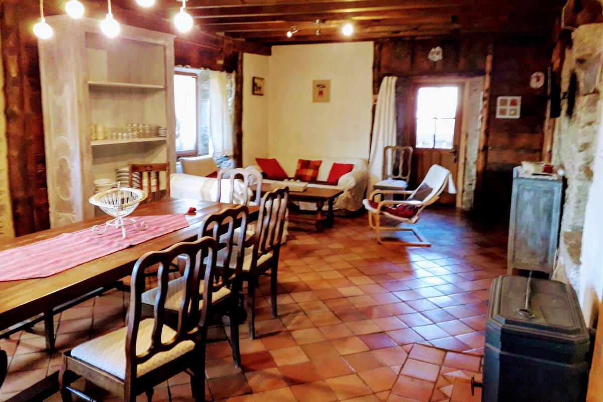 A cozy wooden interior with a dining area, a white sofa, and a chair.