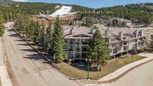 A multi-story hotel with a ski slope in the background. - Walk to Lifts | Easy Access | Wi-Fi | Mountain Spirits 109 (Angel Fire)