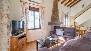 A cozy living room with a fireplace, a television, and comfortable seating. - Las Adelfas del Gastor by Ruralidays (Cádiz)