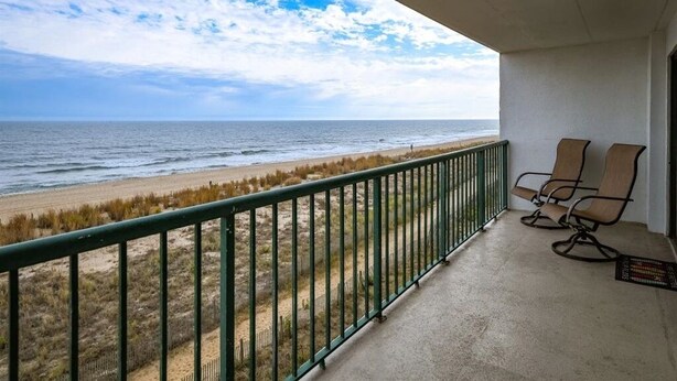 Un balcon avec vue sur la plage et l’océan.
