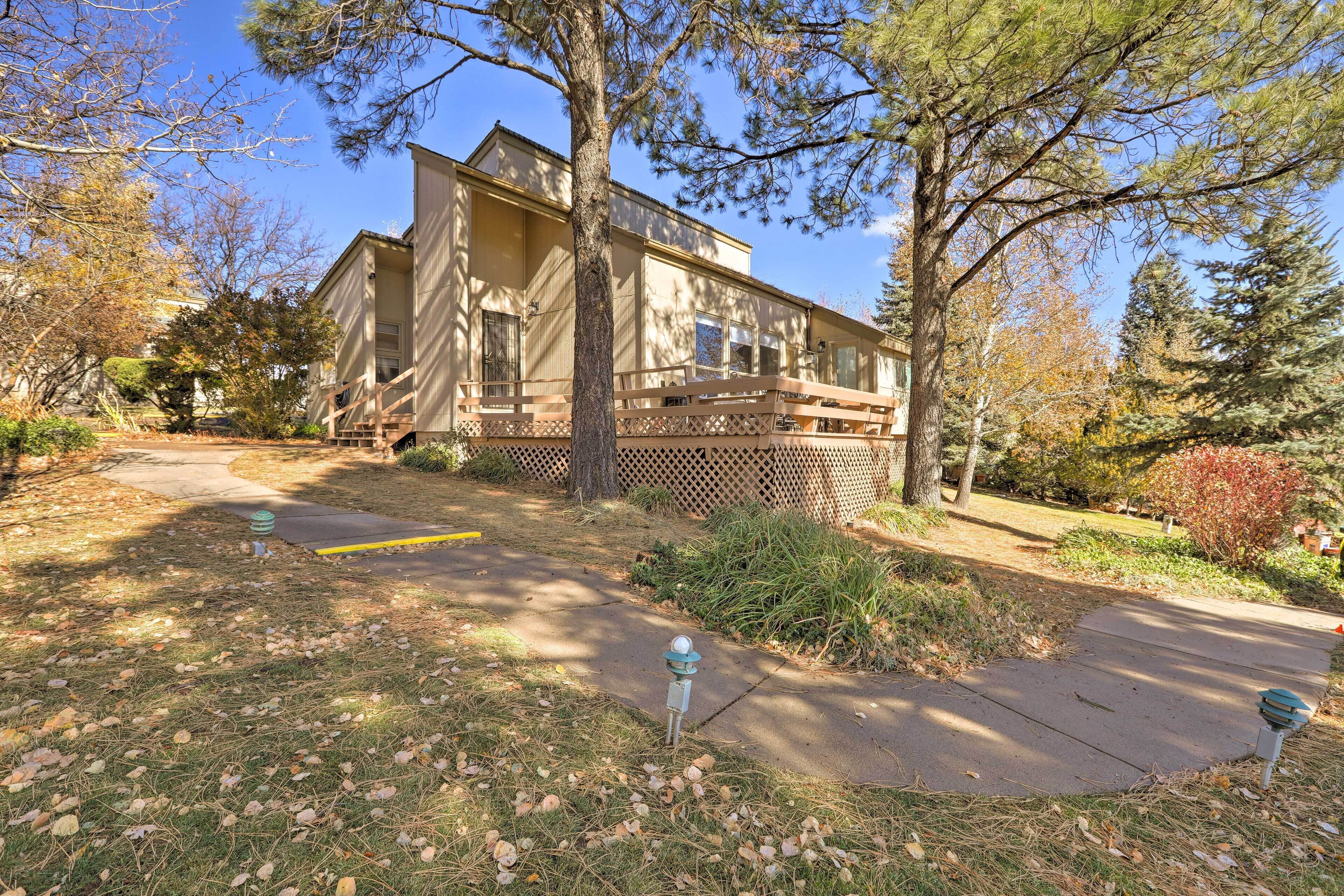 A two-story house with a front porch, a small garden, and a clear sky.