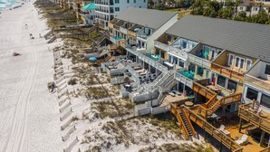 Un hotel sulla spiaggia con numerosi balconi, una spiaggia sabbiosa e una vista limpida sull'oceano.