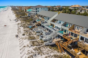 Un hôtel situé en bord de mer, doté de nombreux balcons, d’une plage de sable et offrant une vue dégagée sur l’océan.