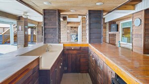 Un interno in legno con angolo cottura, dotato di lavello e pensili.