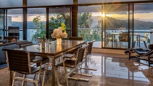 Un comedor moderno con una mesa grande, sillas y vistas del paisaje.